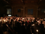 Mensen in de kerk met kaarsen